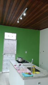 zieloną kuchnię z kuchenką i blatem w obiekcie UM POUCO DE NATUREZA NO LAR w mieście Manaus