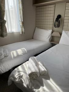 zwei Betten in einem Zimmer mit Handtüchern darauf in der Unterkunft Luxury Holiday Home Sleeps 6 Pet Friendly in St Austell