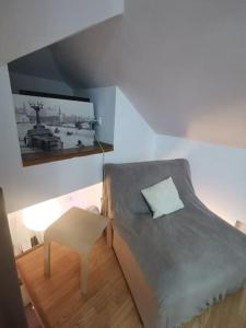 a small bedroom with a bed and a stool at Knez Mihailova apartment - City Center in Belgrade +3 photos