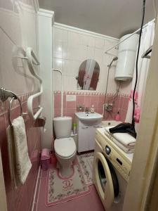 Baño de color rosa con aseo y lavamanos en 2-х комнатная квартира в 5 микрорайоне, en Bishkek