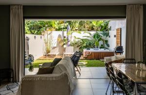sala de estar con sofá y patio en Magnifique villa avec jacuzzi Proximité mer, en Saint-Joseph