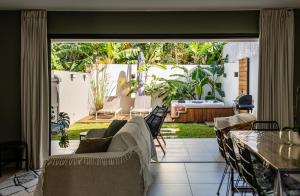 a living room with a couch and a patio at Magnifique villa avec jacuzzi Proximité mer in Saint-Joseph