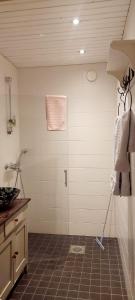 a bathroom with a shower with a door and a tile floor at Apartment Lintu in Mikkeli
