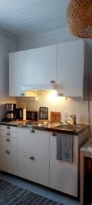 a kitchen with white counters and white cabinets at Apartment Lintu in Mikkeli