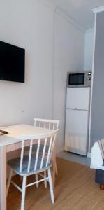 a kitchen with a white table and a white refrigerator at Apartment Lintu in Mikkeli