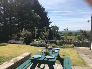 una mesa de picnic con una botella de vino. en Hayfellside Cottage, Sleep 6,3 Bedrooms(1 ensuite), en Kendal