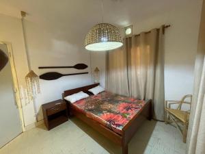 a bedroom with a bed and a large light at Sulas Beach House in Nampula