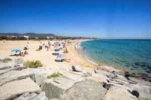 a group of people on a beach near the water at Beach Apartment, next to the sea in Premiá de Mar