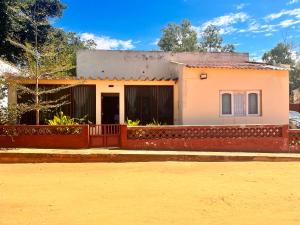 ein kleines Haus mit einem Zaun davor in der Unterkunft Sulas Beach House in Nampula