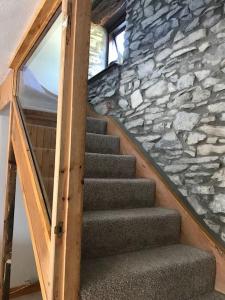 una escalera en una casa con una pared de piedra en Hayfellside Cottage, Sleep 6,3 Bedrooms(1 ensuite), en Kendal