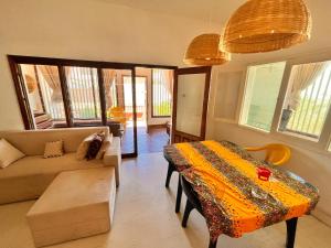 Sulas Beach House في Nampula: غرفة معيشة مع أريكة وطاولة