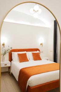 a bedroom with a large bed with orange and white pillows at Charm&Bella GuestHouse in Rome