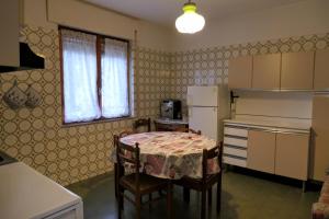 a small kitchen with a table and a refrigerator at Casa Ezio in Malesco