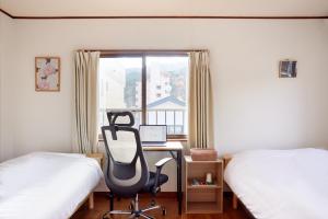 a bedroom with a desk and a chair next to a window at 世界遺産と東武日光駅に近い 全内装 3階まで階段あり 駐車場 子供不可 in Nikko