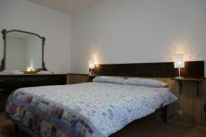 a bedroom with a bed with two lamps and a mirror at Casa Ezio in Malesco