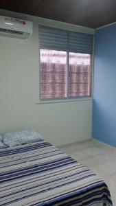 a bedroom with a bed and two windows at UM POUCO DE NATUREZA NO LAR in Manaus