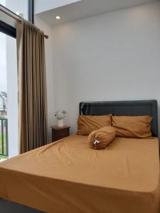 a bed with a flower on it in a bedroom at Orange house Villa in Dau