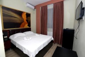 a bedroom with a bed and a flat screen tv at The K Tbilisi in Tbilisi City
