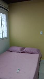 ein weißes Bett in einem Zimmer mit Fenster in der Unterkunft UM POUCO DE NATUREZA NO LAR in Manaus