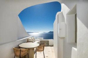 a table and chairs in a room with a view of the ocean at Holiday villa in Oía, Greece in Oia