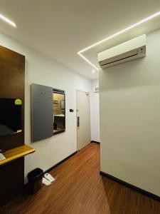 a room with a white wall and a fan at Cyther Stay Hotel in Tawau