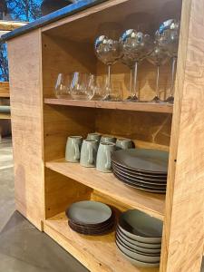 un armario de madera con platos y copas de vino en Cumbres Del Martial en Ushuaia