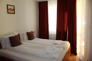 a white bed in a room with a window at PM Services Royal Plaza Apartments in Borovets