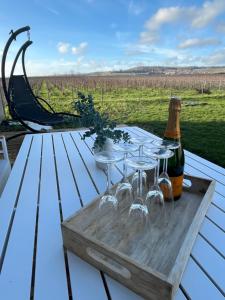 uma mesa de madeira com copos de vinho e uma garrafa em Douceur champenoise em Dizy
