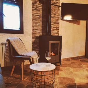 a living room with a fireplace and two wine glasses at Villa pose in Robledillo