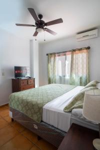 a bedroom with a bed with a ceiling fan at Apart hotel la Trejo in San Pedro Sula