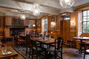 a restaurant with tables and chairs and a fireplace at The Lamb Inn in Hindon