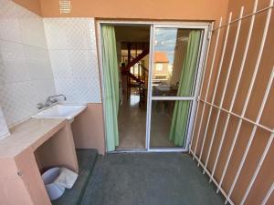a bathroom with a sink and a door to a room at Complejo Cubapart in Las Grutas +69 photos