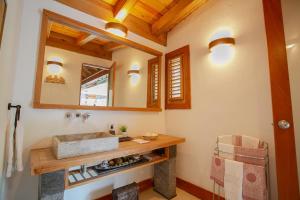 y baño con lavabo y espejo. en Fontana di Rosa, African Style Villa Casa de Campo en La Romana