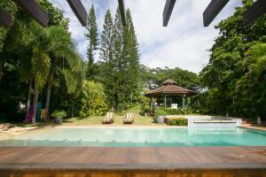 a swimming pool with two chairs and a gazebo at Fontana di Rosa, African Style Villa Casa de Campo in La Romana