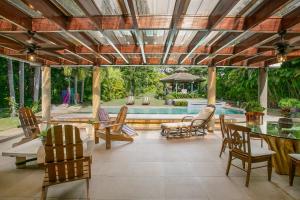 un patio con mesa, sillas y piscina en Fontana di Rosa, African Style Villa Casa de Campo, en La Romana