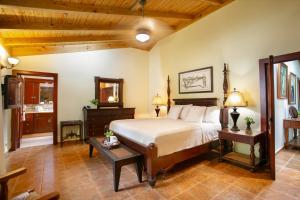 a bedroom with a bed and two tables in a room at Fontana di Rosa, African Style Villa Casa de Campo in La Romana