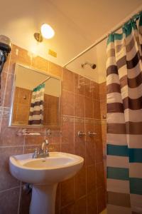 ein Bad mit einem Waschbecken und einer Dusche mit einem Spiegel in der Unterkunft Apart hotel la Trejo in San Pedro Sula
