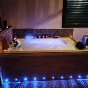 bañera grande con luces en una habitación en Villa pose en Robledillo
