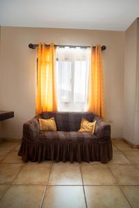 a couch sitting in front of a window at Apart hotel la Trejo in San Pedro Sula