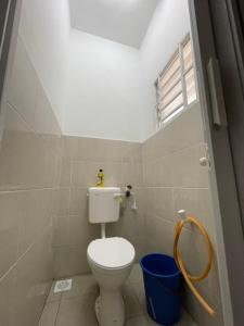 baño con aseo y cubo azul en D'Cahaya Homestay Batu Pahat, en Batu Pahat