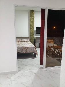 - une chambre avec un lit et un balcon avec une table dans l'établissement Casa Palmamar, à Olón