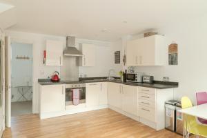 a kitchen with white cabinets and a counter top at Bath Breaks Apartments in Bath