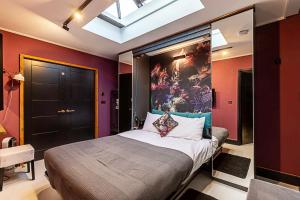 a bedroom with a bed with a painting on the wall at Scarlett Heart Studios in Golders Green in London