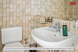 a bathroom with a white sink and a toilet at Beautiful Boutique Apartment DRAHTZUG8 in Zürich