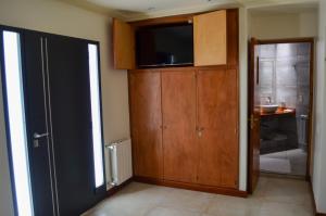 uma sala de estar com uma televisão e um armário com uma porta em Catalina Apart em San Salvador de Jujuy