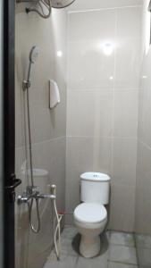 a small bathroom with a toilet and a shower at Orange house Villa in Dau