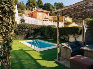 a swimming pool in a yard with a couch and an umbrella at Charming country house Torremolinos in Torremolinos