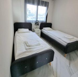 two beds in a small room with a window at Sunset Drive Apartments in Benidorm