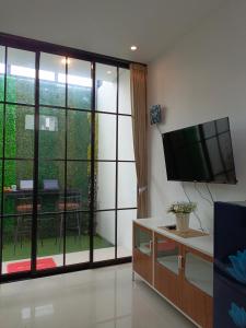 a living room with a flat screen tv on a wall at Orange house Villa in Dau