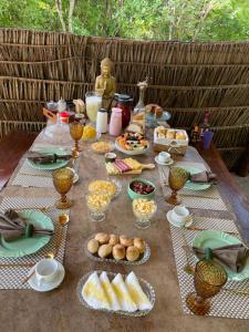 einen Tisch mit Lebensmitteln und Teller mit Lebensmitteln in der Unterkunft Safira Beach House in Pipa